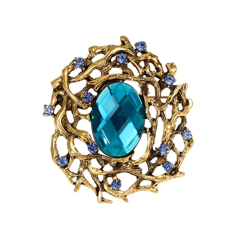 Elegant and timeless gold brooch with blue gemstones and intricate design